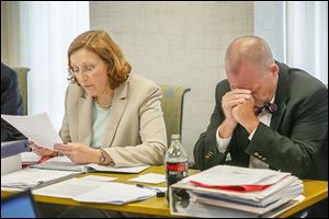 Jennifer Brunner, left, reads a letter from Anthony DiGidio to Ohio Secretary of State Jon Husted and Scott Borgemenke, right, reacts during the hearings for fired board of elections board members and staff at One Government Center on May 15, 2014.