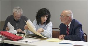 Lucas County Board of Elections member Tony DeGidio looks over paperwork as director Gina Kaczala talks to appointed overseer and retired judge Charles Wittenberg during the board’s meeting Wednesday at the Early Vote Center in Toledo.