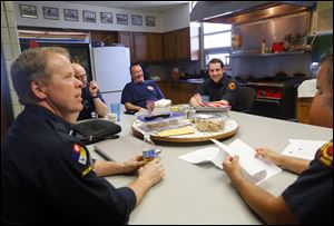 Members of the Toledo Fire Department, from left, Lt. Brian Henry, John Martin, Mike Lester, Barrett Dorner, and Ray Rodriguez socialize at Fire House 7. Most of their down time is spent around the kitchen table, just like any other family.