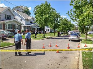 Toledo police officers survey the scene of  shootings in the 2100 block of Joffre Avenue, east of Upton Avenue and Bancroft Street.