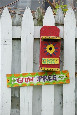 A bird house painted by youth adorns the fence.