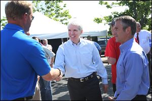 Sen. Rob Portman (R., Ohio), center, greets Chris Ostrander, left, Cooper Tire & Rubber Co.‘s president of North American Tire Operations,  and Tom Lause, vice president of finance,  after addressing a crowd of employees Thursday at Cooper Tire & Rubber Co. in Findlay.
