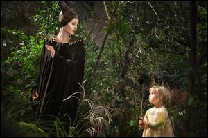 Angelina Jolie as Maleficent, left, in a scene with her daughter Vivienne Jolie-Pitt, portraying Young Aurora.