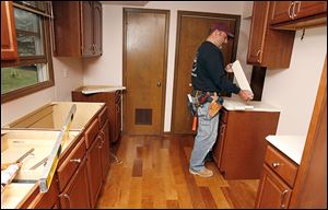 Kevin Krueger installs a countertop during a kitchen remodel in Naperville, Ill. RealtyTrac Inc. said the gross return on investment on flipped houses was 2.3 percent in the last year in Lucas County.