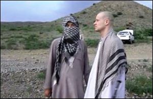 Sgt. Bowe Bergdahl, right, stands with a Taliban fighter in eastern Afghanistan. The Taliban released a video today showing the handover of Bergdahl to U.S. forces in eastern Afghanistan.