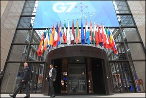 Two security guards pass the entrance of the European Council building in Brussels ahead of a two-day G7 meeting, today.