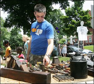A festival-goer looks through the goods at one of the dozens of garage sales during the festival.