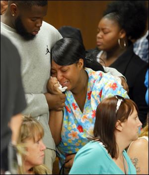 A sister of the suspect, who did not wish to be identified, reacts during the arraignment.