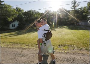 Hunter Gandee, 14, began a 40-mile walk to Ann Arbor on Saturday, carrying his brother Braden, 7, on his back.
