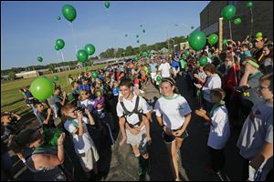 Hunter, carrying his brother Braden, left, walks with sister Kerragan as they begin the journey. 