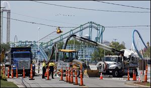 Crews work to repair a water main break near the entrance to Cedar Point  Saturday. Would-be park visitors were turned away at the entrance.
