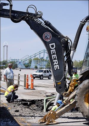 Crews work to repair a water main break Saturday near the entrance to Cedar Point 