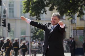 Ukrainian President Petro Poroshenko lifts his arms in greeting after the inauguration ceremony today in Sophia Square in Kiev, Ukraine.
