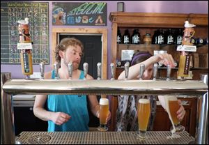 Bar manager Lenny Kromer and bartender Taylor Fletcher fill glasses with beer at the Catawba Island Brewing Co.'s Tasting Room in Port Clinton, Ohio.