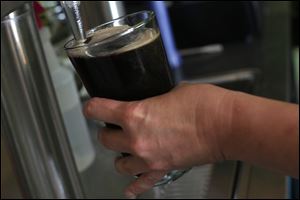 Bartender Sherri Daver pours a Sylvania Stout for a customer at Sugar Ridge Brewery in Bowling Green. 
