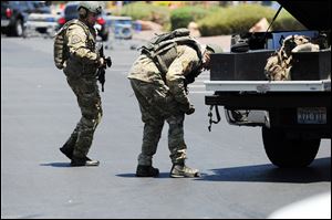 Authorities say two suspects shot and killed two police officers at a Las Vegas eatery Sunday before fatally shooting a third person and killing themselves inside a nearby Walmart.