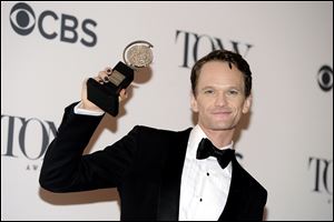 Neil Patrick Harris poses with his award for best performance by an actor in a leading role in a musical for his role in 