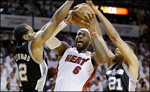 San Antonio’s Tim Duncan, right, and Kawhi Leonard, left, defend Miami’s LeBron James during the first half in Game 3 on Tuesday night in Miami.
