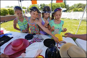Perrysburg children, from left, Natalie French, 9, Megan Gibbs, 9, Lauren Swartz, 10 and Reagan Wilkinson, 8, are quizzed on which hat provides the best protection from the sun as they learn the basics of sun safety around the municipal pool.