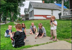 Children play near an abandoned home at 951 Prouty Ave. in South Toledo.