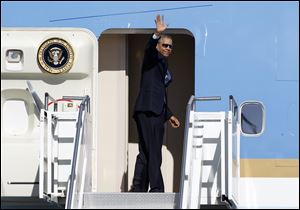 President Barack Obama waves in the direction of members of the media as he boards Air Force One today at Palm Springs International Airport in Palm Springs, Calif. 