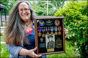 Alice Lemle holds the medals of her father-in-law, Victor Lemle, who was awarded a Purple Heart for his actions during World War II.