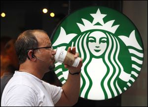 A man drinks a Starbucks coffee in New York.