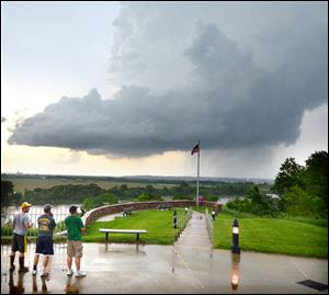 Onlookers standing at the Sgt. Floyd Monument in Sioux City, Iowa, watch as a storm cell passes over the city today.