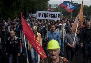 Miners, one of them carrying a sign with the name of the mine Trudovskaya, march in support of peace in Donetsk, eastern Ukraine, today. Hundreds of miners went on a protest walk trying to express support for a peaceful resolution to the eastern Ukraine conflict.