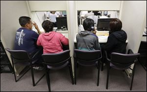 People use a a phone bank to sign up for health care insurance at the business office of Parkland Hospital in Dallas. 
