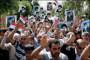 Iraqis living in Iran hold a demonstration against Sunni militants of the al-Qaida-inspired Islamic State of Iraq and the Levant, or ISIL, and to support the Grand Ayatollah Ali al-Sistani, Iraq's top Shiite cleric, shown in the posters, as some of them hold posters of the Iranian Supreme Leader Ayatollah Ali Khamenei.
