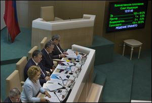 Speaker of Federation Council members Valentina Matviyenko, second left, looks at the screen in front of her during the voting in the Russian parliament's upper chamber in Moscow, Russia, today.