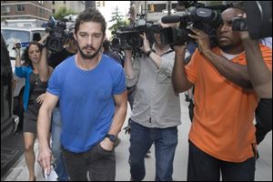 Shia LaBeouf walks through the media Friday in New York after leaving Midtown Community Court following his arrest the previous day for yelling obscenities at the Broadway show ‘‍Cabaret.’