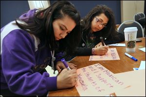 University of Toledo students AnaPatricia Marquez, left, Anissa Covarrubias, right, create small posters in support of citizens of Venezuela during a meeting put on by the South American and Hispanic Students Association at UT in April. Both girls are members of the Latino Student Union and had turned out in support of their Venezuelan classmates. 