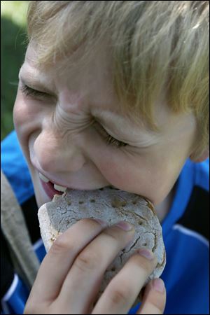 Kidsplay Silas Keaton, 7, struggles to bite into a piece of hard tack.