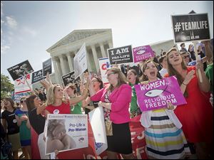 Demonstrators react to the Supreme Court’s decision on the Hobby Lobby case outside the building in Washington. Justices ruled 5-4  for the family owned craft-store chain and a cabinet-making business.