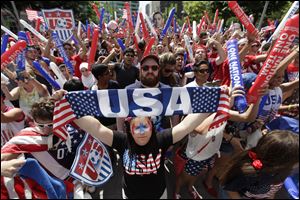 Amber Silvani, of Southgate, Mich., holds up a USA banner as United States fans react while watching before the 2014 World Cup soccer match between the United States and Belgium at a public viewing party, in Detroit.