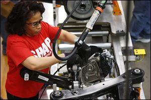 An assembly line worker builds a 2015 Chrysler 200 automobile at the Sterling Heights Assembly Plant in Sterling Heights, Mich. 