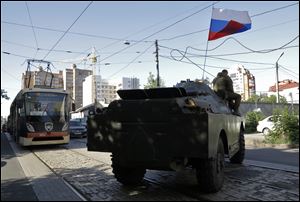 A pro-Russian fighters' APC travels near the captured Interior Ministry headquarters in Donetsk, eastern Ukraine Tuesday. The rebels captured the Interior Ministry headquarters in the city after an hours-long gun battle.
