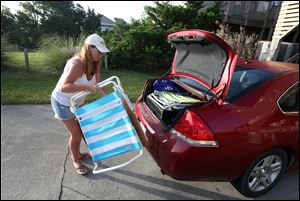 Carol Palmer of King George, Va.  loads a car with her family's belongings as they prepare to leave Hatteras Village, N.C.