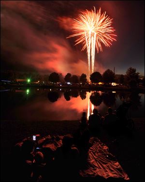 People watch a fireworks display to commemorate the Independence Day holiday, Thursday night, July 3, 2014, in Owensboro, Ky.