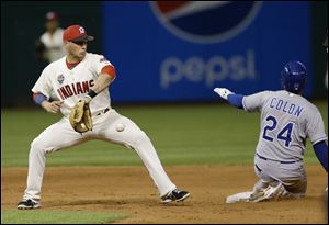 Kansas City Royals' Christian Colon, right, slides safely into second base on an RBI-double as Cleveland Indians' Asdrubal Cabrera waits for the ball in the ninth inning.