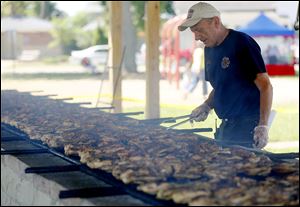 Volunteer firefighter Assistant Chief Ernie Gehrke tends to the grilled chicken during Whitehouse’s sesquicentennial celebration.
