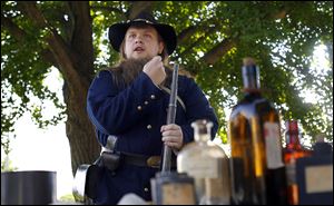 Civil War re-enactor Tyler Bury gives a presentation about loading a musket during the Whitehouse celebration. The village was founded in 1864.
