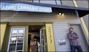 Cannabis City owner James Lathrop briefly leans against the exterior of his new recreational marijuana store Monday in Seattle. The shop will be the first and, initially, only store in Seattle to legally sell recreational pot when sales begin today.