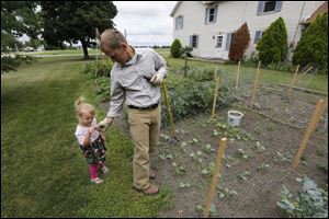 Audrey and her dad share a snap pea.