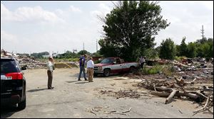 Mayor D. Michael Collins, Chief of Staff Bob Reinbolt, and Joel Mazur, assistant chief of staff, investigate two men taking bricks from the former Champion Spark Plug plant on Upton Avenue. Collins and Reinbolt also caught two men in the process of illegal dumping.