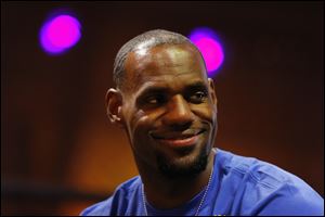 NBA basketball star LeBron James, shown in Brazil while attending the World Cup, will bring hundreds of millions in revenue to Cleveland.