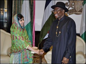 Pakistani activist Malala Yousafzai, left, shakes hands with Nigerian President, Goodluck Jonathan, right, at the Presidential villa, today in Abuja, Nigeria.