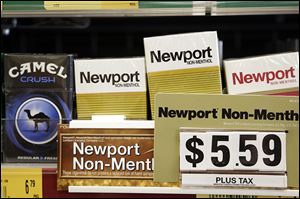 Camel, a Reynolds American brand, and Newport, a Lorillard brand, cigarettes are displayed for sale on Tuesday in Doral, Fla. Reynolds will buy its smaller rival Lorillard for $27.4 billion.